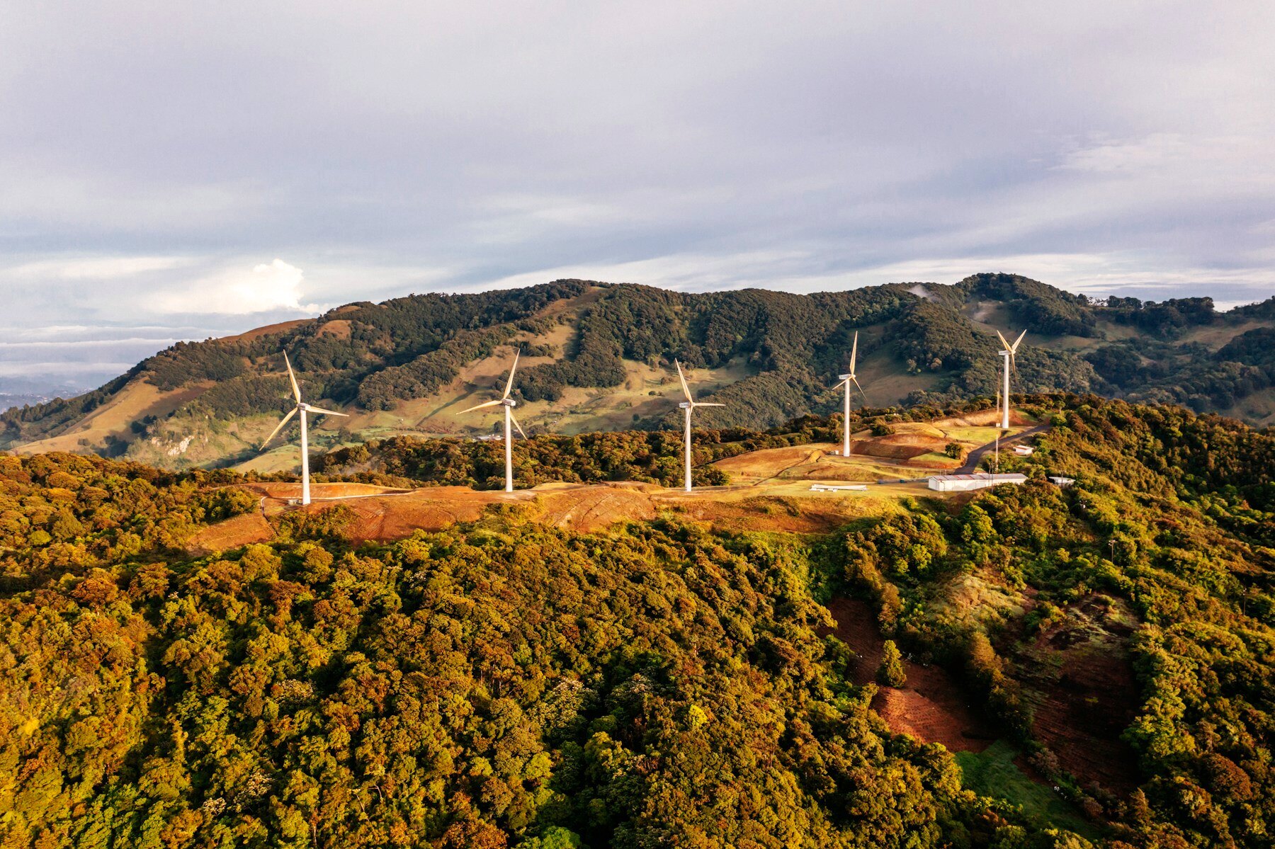Wind turbines on a green mountain ridge in Costa Rica